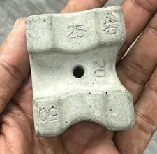 Small plaster or concrete spacer casting held in a hand
