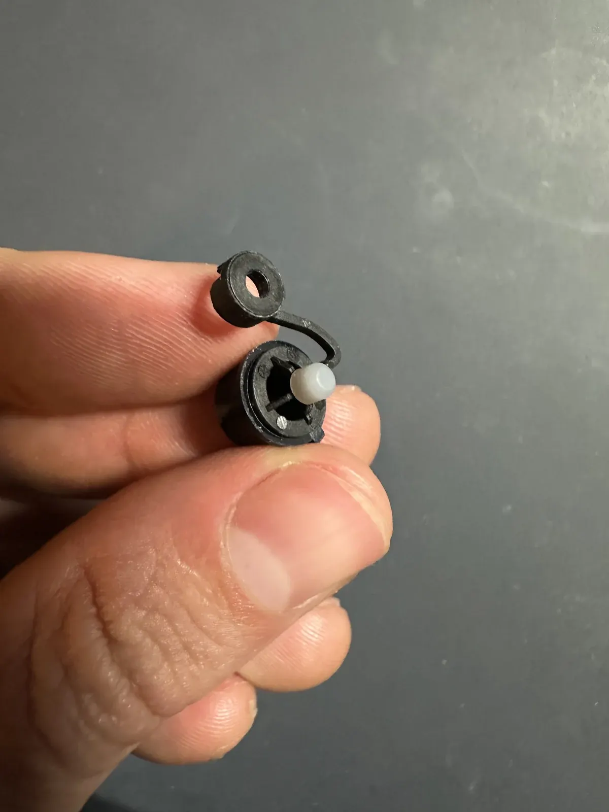 Small custom silicone rubber dome held between fingers
