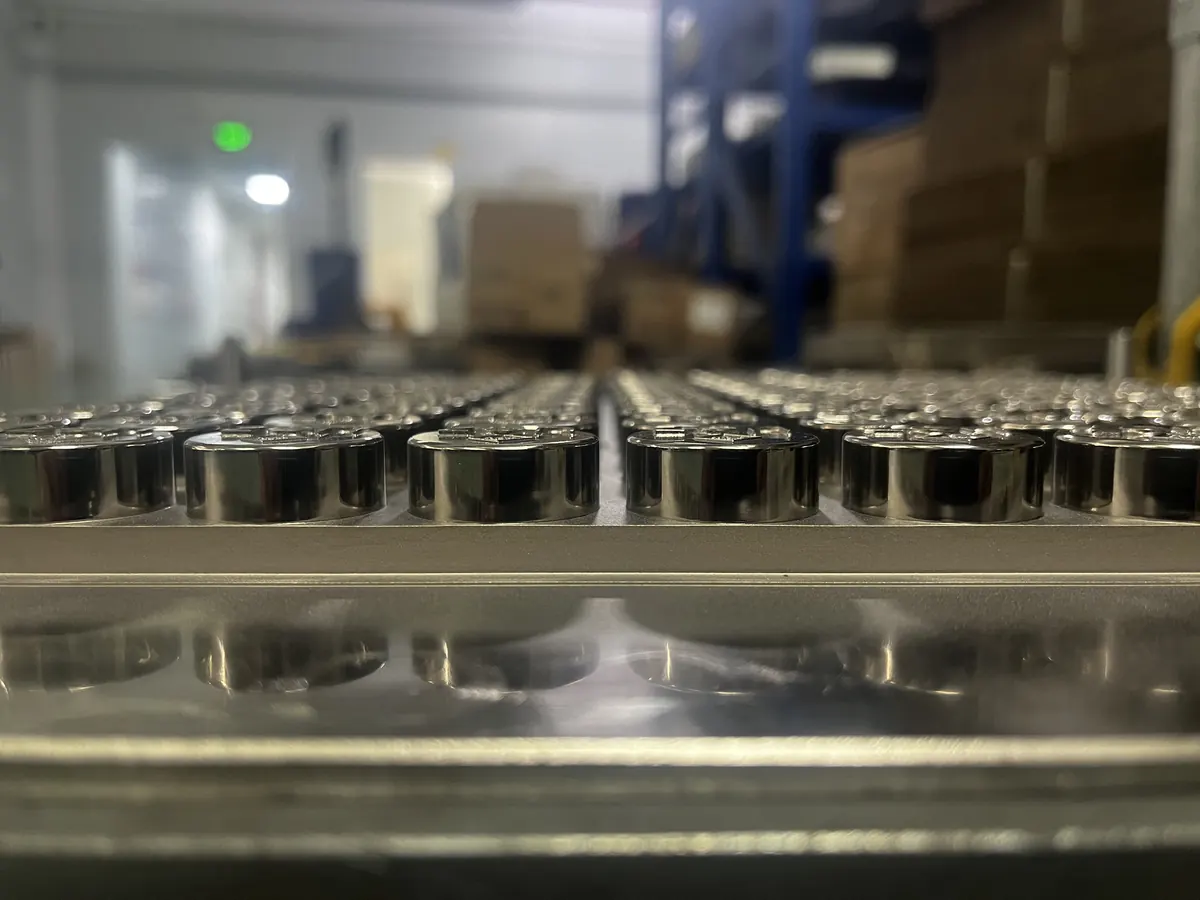 Steel gummy cavity inserts in a production plate, viewed at tray height