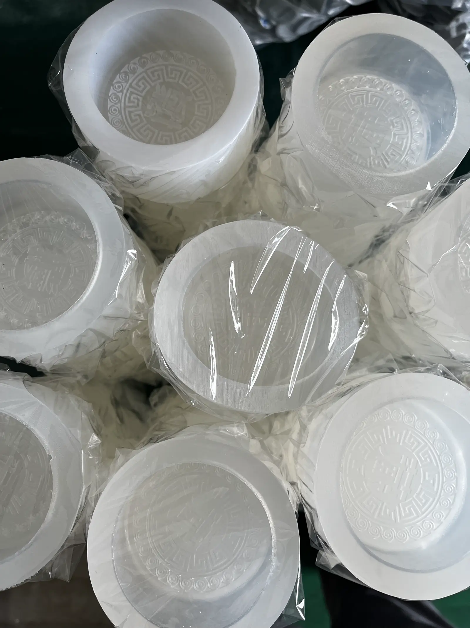 Several bagged round silicone molds with different center characters